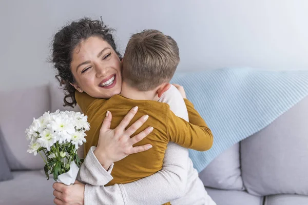母とソファーにぴったりの花の花束と小さな息子 — ストック写真