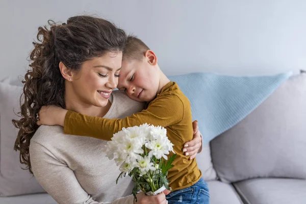 Mother Little Son Bouquet Flowers Hugging Sofa — Stock Photo, Image