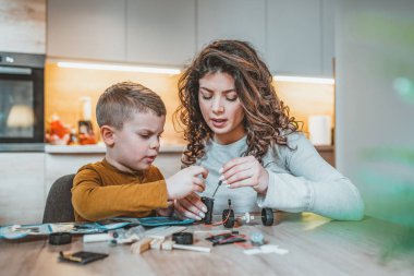 Anne ve oğlu bir robot inşa ederken konsantre ol. Anne oğlu ile elektronik proje yardım. Evde anne oğlu Robotik hakkında öğretir