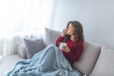 Genç kız yatakta dokusu içine hapşırma ve sıcak çay içme ateşi tutan sıcaklık ile hasta