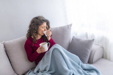Genç kız yatakta dokusu içine hapşırma ve sıcak çay içme ateşi tutan sıcaklık ile hasta
