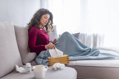 Grip duygu, ateşi olan ve mendil ile burun akıntısı üfleme sarılmış battaniyeye, yatağın üstüne oturan sefil kadın