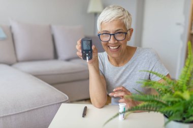 Evde kan şekeri testi. Evde kan şekeri seviyesini kontrol ediyorum. Diyabetik kontrol kan şekeri düzeyleri. Kadın evde glucometer ve test şerit tarafından kan şekeri seviyesini kontrol