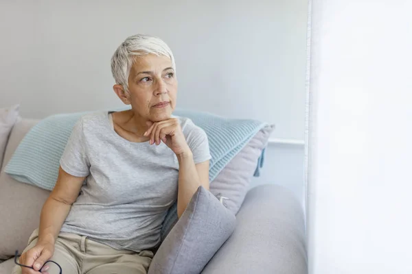 Volwassen Grijs Haired Vrouw Zittend Bank Poseren Thuis — Stockfoto