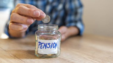 Cam kavanozda bozuk paraolan adam ellerini, yakın. Sorumlu yatırım. Pension. Sikkeve yazıt lı cam kavanoz. Adam elinde bozuk para tutar 