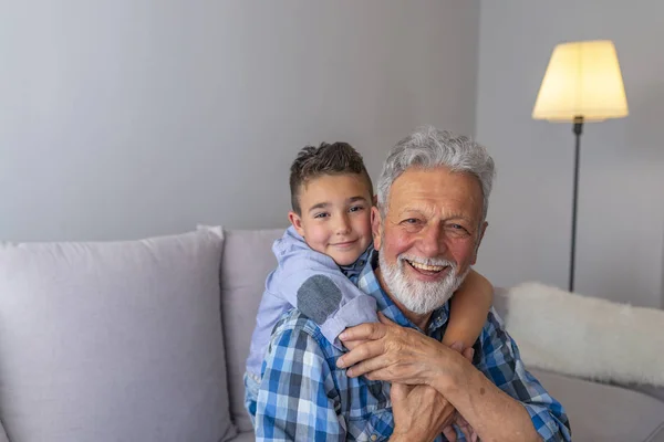 Strzał Szczęśliwy Starszy Mężczyzna Uśmiechnięty Patrząc Kamerę Jego Wnuka Przytulanie — Zdjęcie stockowe
