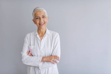 Kıdemli kadın doktor. Kadın doktor gülümsüyor ve kameraya bakıyor. Kameraya bakan güzel olgun kadın doktor portresi. Güzel kadın doktor. Tıbbi konsept 