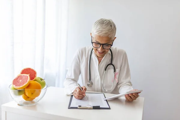 Perempuan Ahli Gizi Menunjukkan Sayuran Dan Buah Dokter Menulis Dokumen — Stok Foto