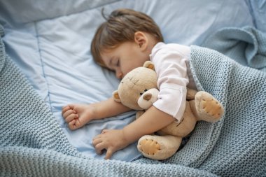 Sevimli küçük çocuk uyuyor. Küçük çocuk yatakta uyuyan Sevimli küçük çocuk uyku, yorgun çocuk onun küçük yatakta bir şekerleme alarak, temiz, taze ve rahat yatak çarşafları, çocuklar için yatmadan