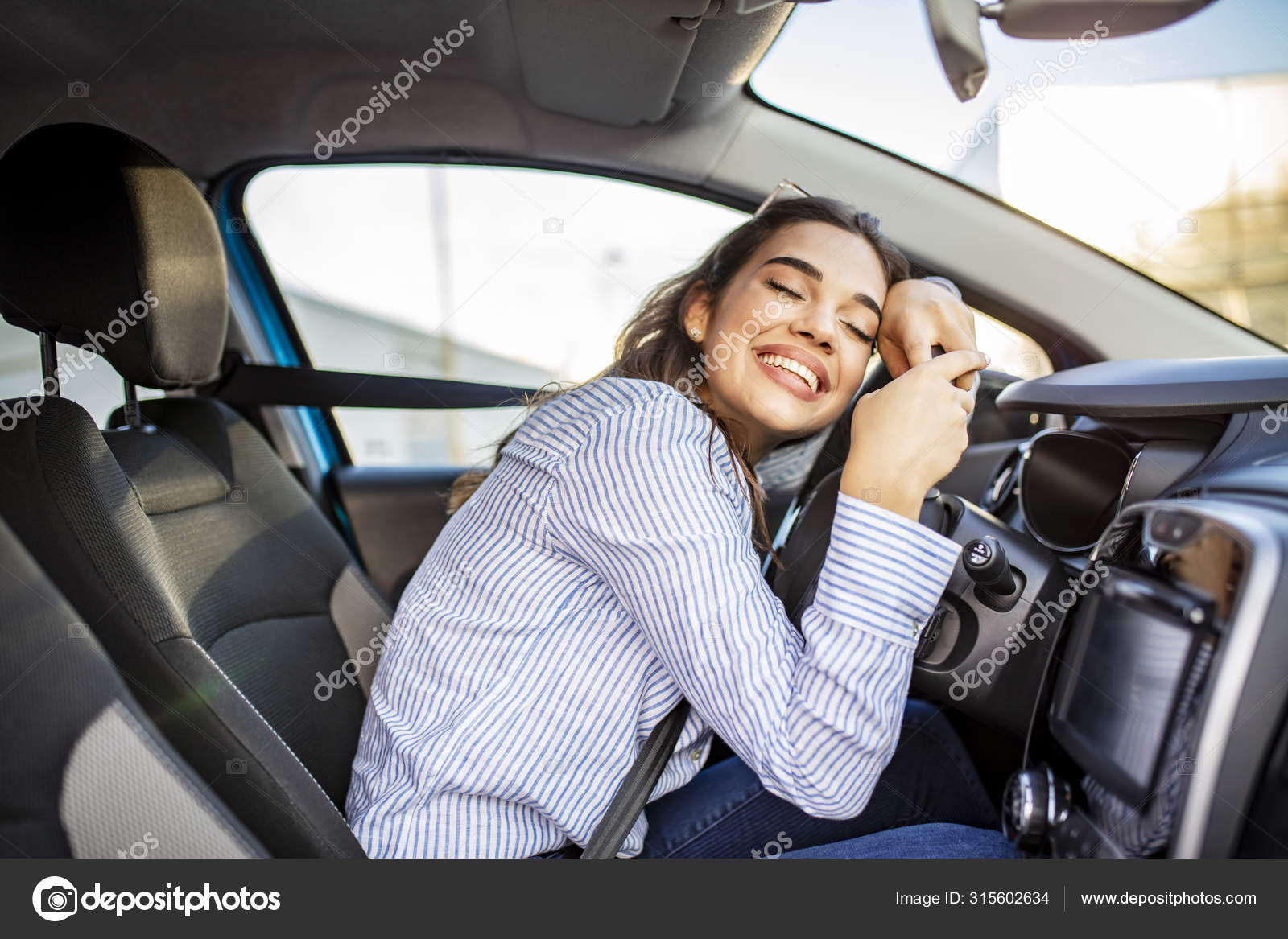 Die Frau auf dem Beifahrersitz durch das Lenkrad Stockfotografie