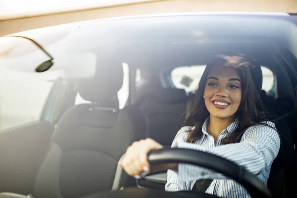 美しい若い幸せな笑顔の女性は日没時に彼女の新しい車を運転する 車の中の女幸せな表情の女性を見て楽しいの肖像画を閉じます 車を運転カジュアルウェアの女性 — ストック写真