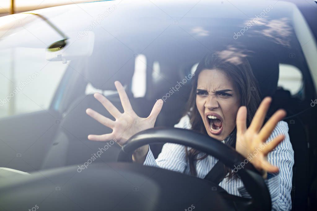 Window portrait displeased stressed angry pissed off woman driving car annoyed by heavy traffic isolated street background. Emotional intelligence concept. Negative human face expression