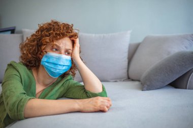Virüs salgını yüzünden izole edilmiş bir kadın. COVID-19 sırasında güvenlik ve korunma için koruyucu yüz maskesi takan bir kadın. Maskeli kadın - grip virüsüne karşı koruma. 
