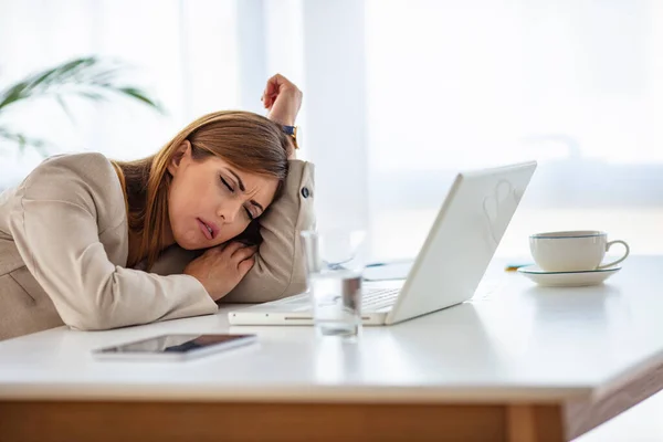 仕事中の若い疲れた働く女性 疲れたビジネスの女性が机の上で頭を休めている 疲れとストレスを感じる オフィスで彼女の職場に座っている間 目を閉じて保つ欲求不満若い女性 — ストック写真