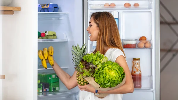 냉장고에서 나먹을 수있는 샐러드를 냉장고에 있습니다 여자가 냉장고를 카메라를 보면서 — 스톡 사진