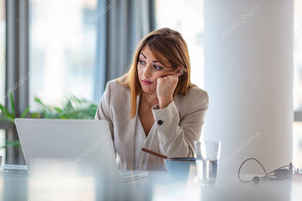 Thoughtful business woman looking away feeling bored pensive thinking of problem solution in office with laptop, serious hindu employee searching new ideas at work unmotivated about dull job