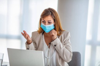 Hasta ile internetten konuşan portre kadın doktor, video görüşmesi yapan, kameraya bakan, steteskop konuşan beyaz üniformalı genç kadın, danışmanlık ve terapi konsepti.
