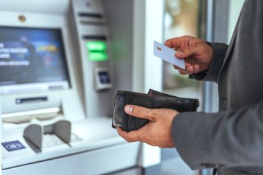 Bankacılık amacıyla ATM 'ye bir kart eklemek, finansal teknolojiyi ve kolaylığı vurgulamak.