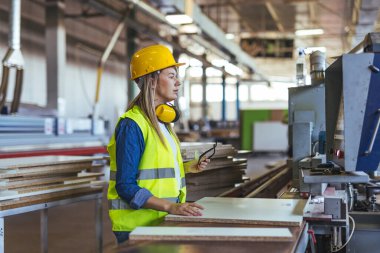 Modern bir fabrikada ekipman kullanan sanayi işçisi. Operasyonlar sırasında hassasiyet ve güvenliği sağlamak. Kask, güvenlik gözlükleri ve kulaklıklarla donatılmış yüksek yapılandırılmış ve organize edilmiş bir çalışma alanı..