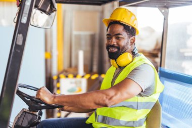 Endüstriyel işçi çalışma makineleri, güvenlik teçhizatı ve başlık takmak, profesyonellik ve güveni iyi organize edilmiş bir depo ortamında yaymak.