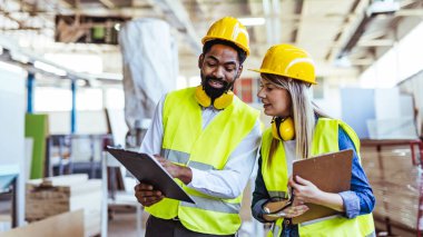 İnşaat alanında panolarla çalışan iki mimar.