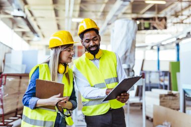 İnşaat alanında panolarla çalışan iki mimar.