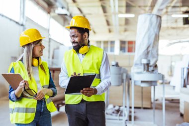 İnşaat alanında panolarla çalışan iki mimar.