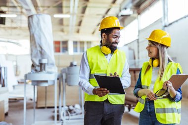 İnşaat alanında panolarla çalışan iki mimar.