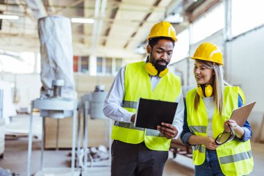 İnşaat alanında panolarla çalışan iki mimar.