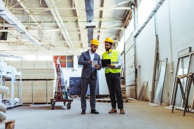 Depoda güvenlik ekipmanı takan iki profesyonel işçi