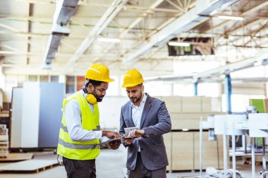 Depoda güvenlik ekipmanı takan iki profesyonel işçi