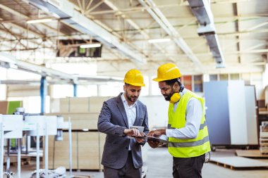 Depoda güvenlik ekipmanı takan iki profesyonel işçi