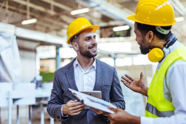 Depoda güvenlik ekipmanı takan iki profesyonel işçi