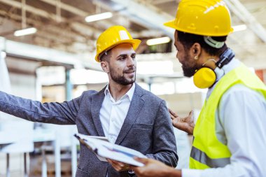 Depoda güvenlik ekipmanı takan iki profesyonel işçi