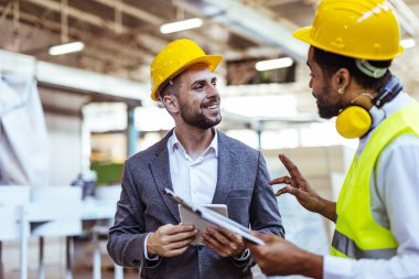 Depoda güvenlik ekipmanı takan iki profesyonel işçi