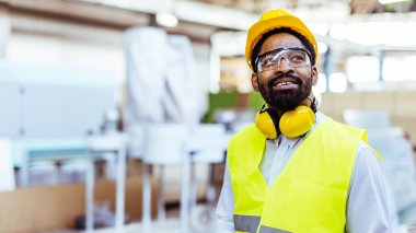 Depoda sarı kasklı ve güvenlik gözlüklü Afro-Amerikan erkek mühendis