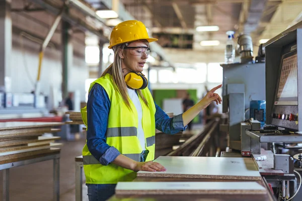 Fabrika ortamında modern makineleri çalıştıran güvenlik kıyafeti giyen işçiler, profesyonel endüstriyel süreçler ve güvenlik uyumunu gösteriyor.