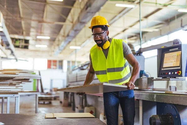 Koruyucu yelek ve kask giyen işçiler, üretim kalitesi ve güvenlik önlemlerine odaklanarak, modern endüstriyel çalışma alanındaki makine parçalarıyla ilgileniyorlar..