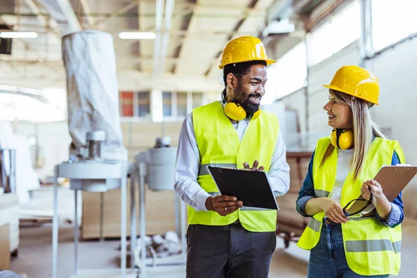 İnşaat alanında panolarla çalışan iki mimar.