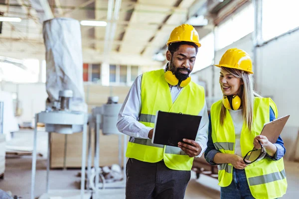 İnşaat alanında panolarla çalışan iki mimar.