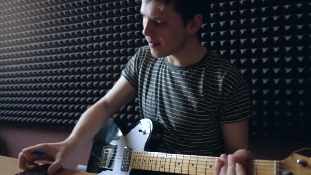 Musiker spelar på electro gitarr i studion. — Stockvideo