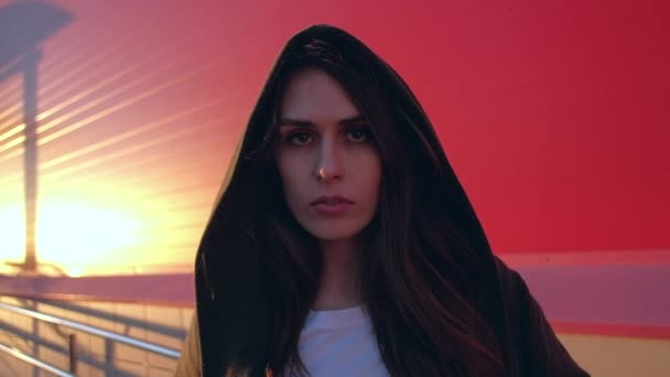 Porträtt av fantastiska mystiska kvinna med långt hår, titta i kameran med en strikt look på röd bakgrund. — Stockvideo