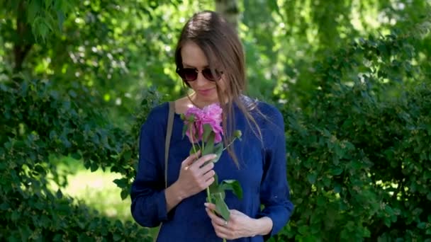Mujer joven con flor de peonía — Vídeos de Stock