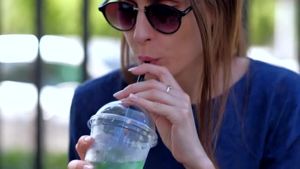 Une fille dans un café buvant un cocktail Mojito . — Video