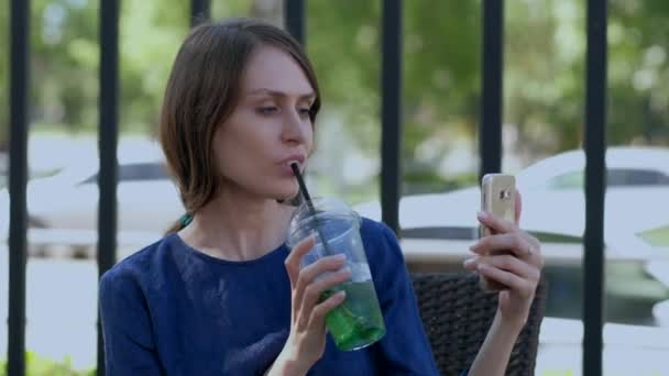 La chica en la terraza en el café tomando una selfie . — Vídeos de Stock