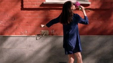 Slowmotion. Sokaktaki atlama ve bir çiçek ile dans kız