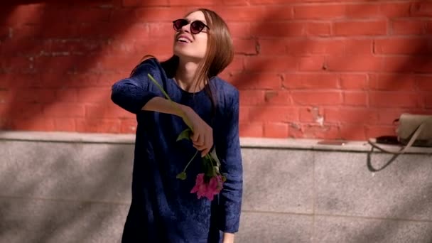Slowmotion. flicka på gatan spinning med en blomma — Stockvideo