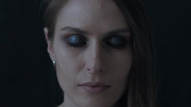 Siyah bir zemin üzerine güzel bir kadın portresi. O gözlerini açar.