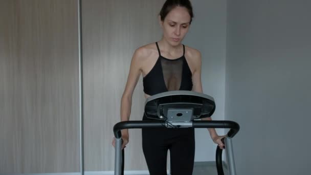 Attractive woman running at home on a treadmill — Stock Video