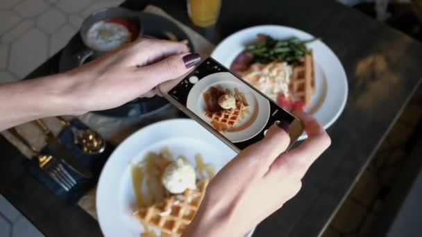 Weibliche Hände fotografieren Lebensmittel mit dem Smartphone